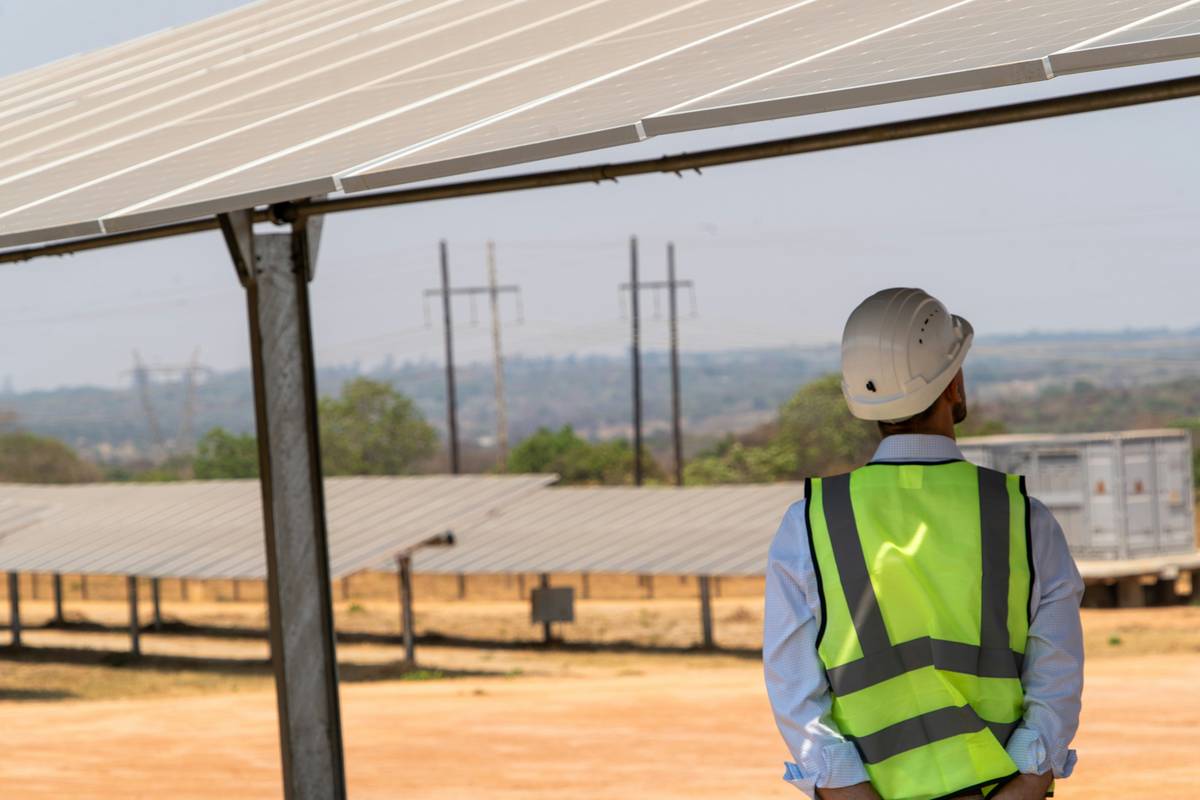Technician performing solar panel system repairs on rooftop array