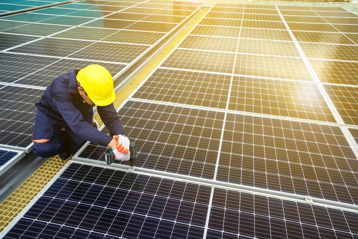 Homeowner inspecting solar energy panel maintenance checklist on rooftop